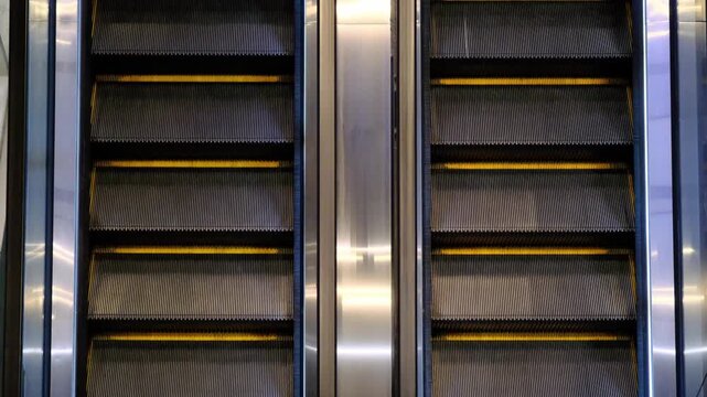 the steps of an empty escalator move up close up view from above