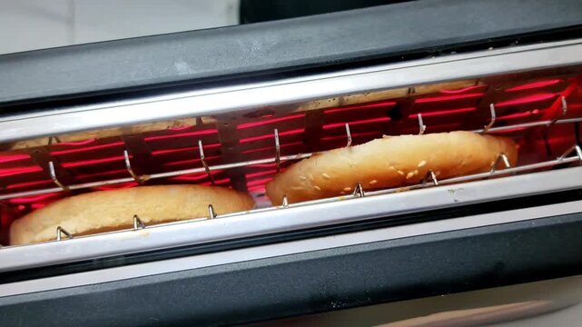 Top view of Round Briosh bread toast popping up from black toaster
