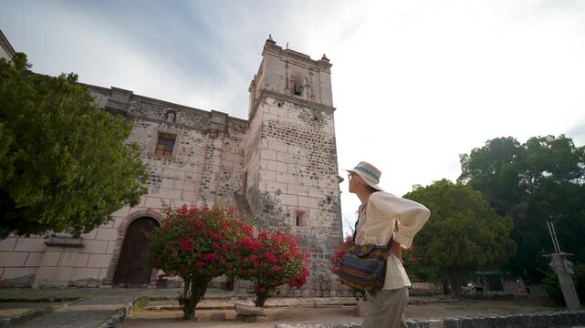 Mature woman explores Mission Church in San Ignacio, Baja California, embracing the sights and sounds of this historic location.