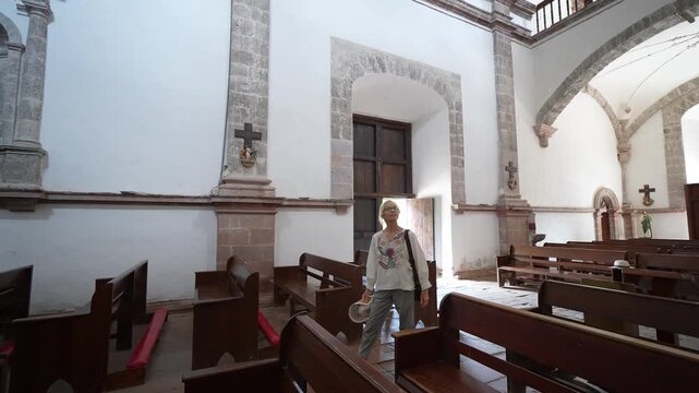 Mature woman walks through Mission San Ignacio in Baja California Sur, Mexico and discovers the beauty of the church and its surroundings.