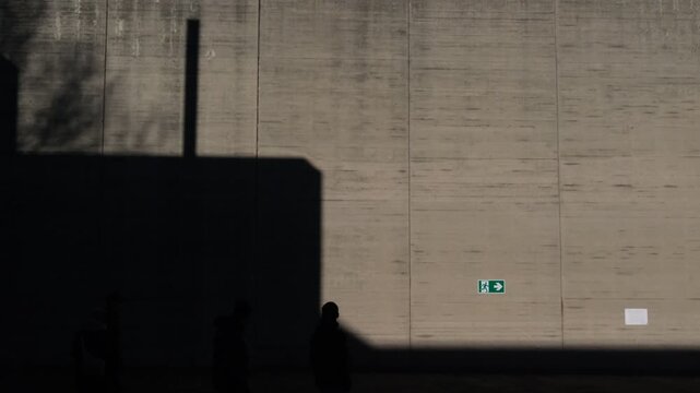 Ombre sul muro in cemento che passano da sinistra verso destra