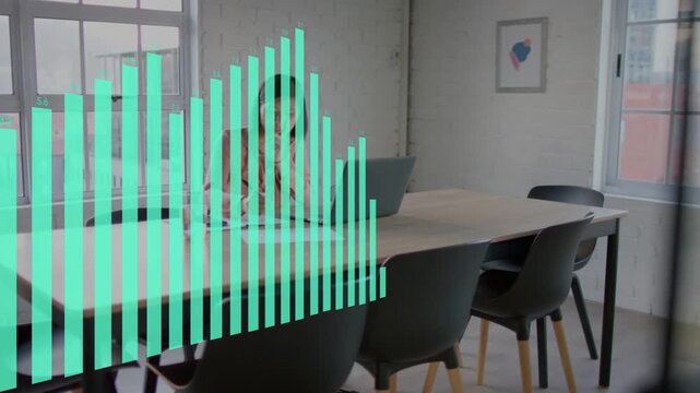 Woman holding phone and using laptop in business, laptop initiating teal bar graph showing data