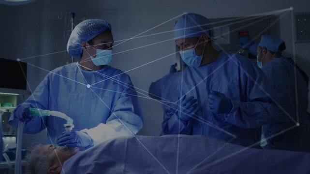 Left clinician placing mask, securing airway for surgery, assistant monitoring, overlay appearing