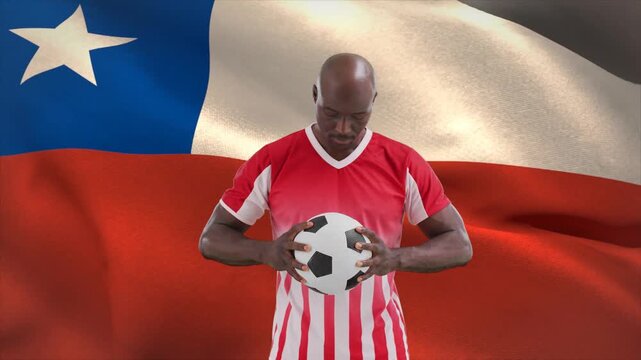 Soccer player adjusting grip, lifting head and facing camera while flag waving, showing pride