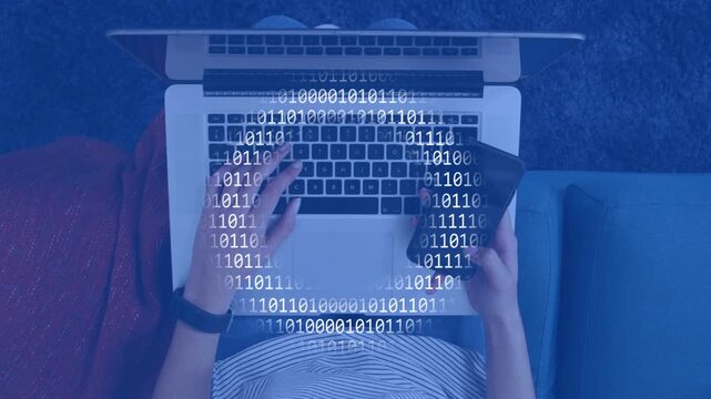 Adult female typing on laptop and tilting phone, initiating binary overlay showing tech data flow