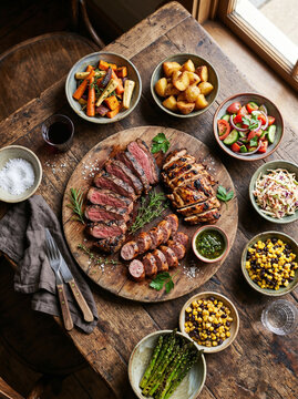 T&aacute;bua de carnes grelhadas com legumes e acompanhamentos r&uacute;sticos