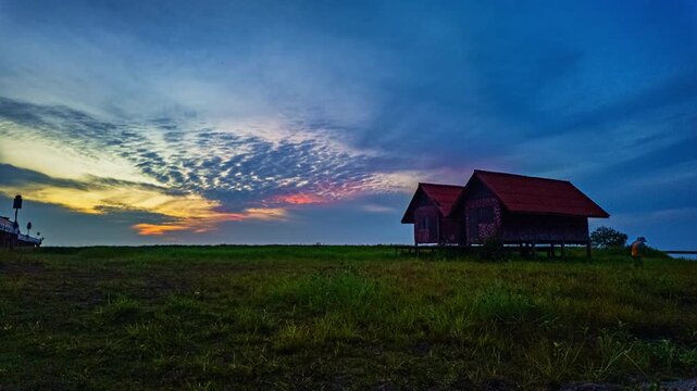 A beautiful natural background showcasing serenity, soft clouds, and warm golden tones of a Pattalung sunset, creating a calm and peaceful atmosphere across the open countryside landscape.