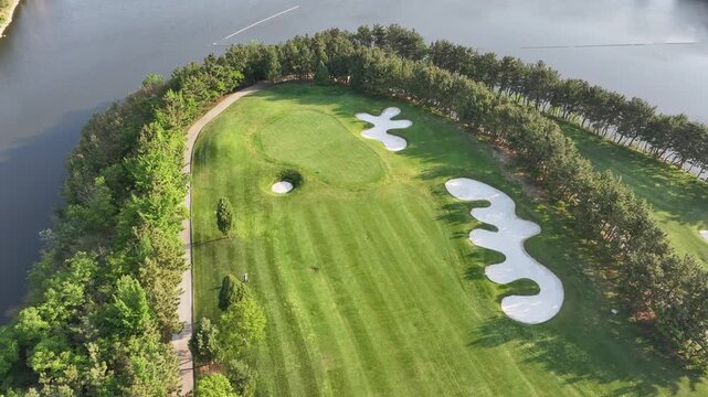 Aerial view of a lakeside golf course with lush green fairways and sand traps