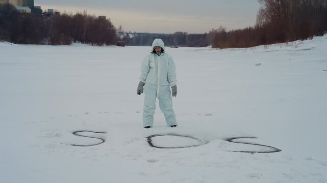 Scientist stands beside large sos in snow on frozen plain near tree line, hooded protective suit and gloves, scanning horizon with patient stance, implied radio communication, tense anticipation