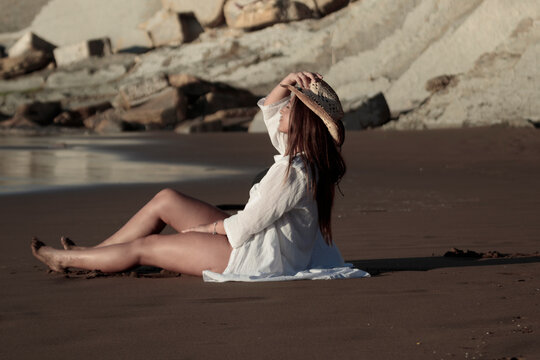 Woman relaxing at beach during golden hour sunset