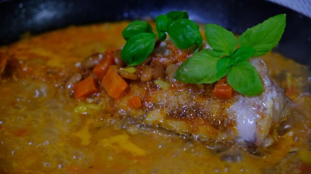 Fresh Red Snapper hot in the frying pan with carrot, garlic, basil,  savoury sauce, vegetables garnish. Brazil food. Sebastes babcocki fish. A deep fried fish topped with chili.