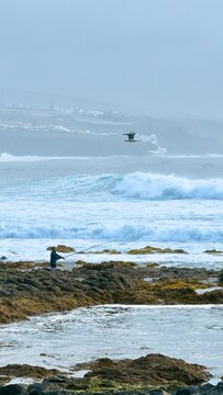 Hombre pescando con el mar bravo