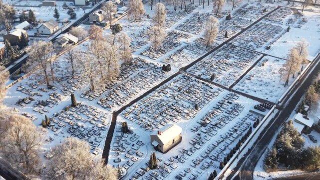 Frozen cemetery with rows of graves and bare trees