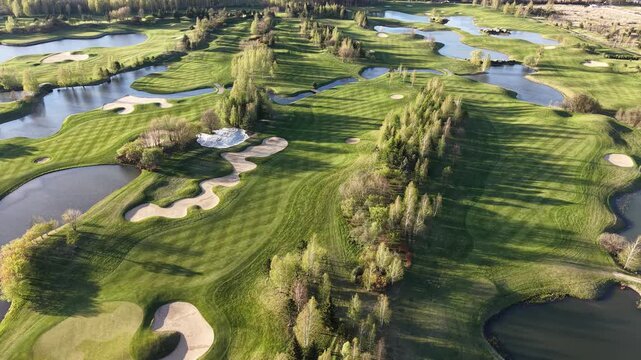 Drone view of golf course with forest and lakes