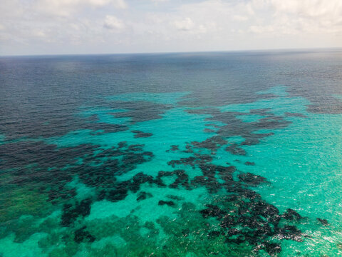 Aerial view of the turquoise Mediterranean waters and rocky seabed along the coast of Sa Coma, Balearic Islands, Spain.
