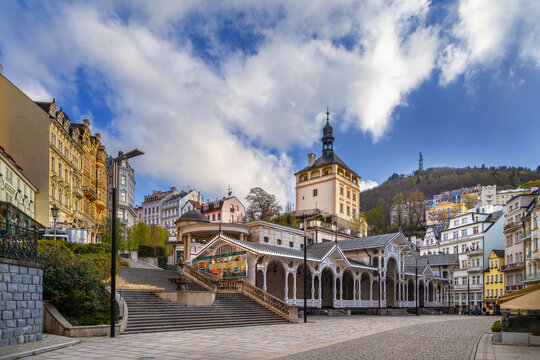 Castle Tower and Market Colonnade in Karlovy Vary, Czech Republic. Historic architecture and wooden pavilion under cloudy sky