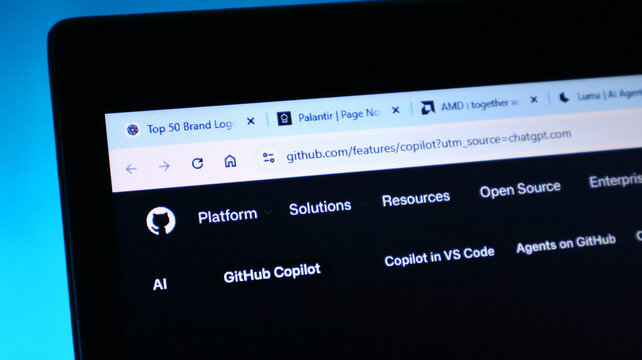 Closeup of a laptop screen displaying the github copilot website in a web browser with multiple tabs open