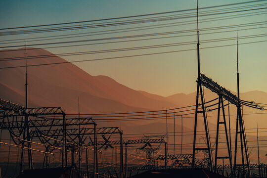 Electric power lines and substation with mountains at sunset
