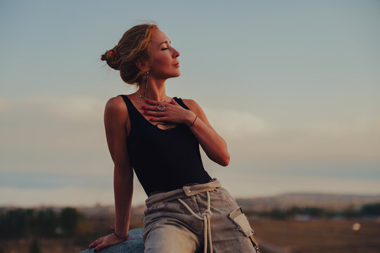 Elegant woman portrait at sunset over mountain