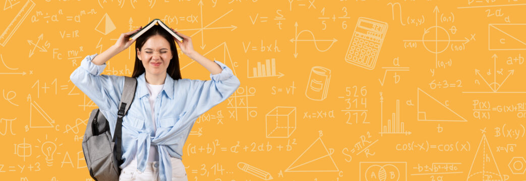 A student stands in front of a bright background filled with math symbols. She holds a notebook over her head and makes a funny face. She wears a backpack and casual clothes.