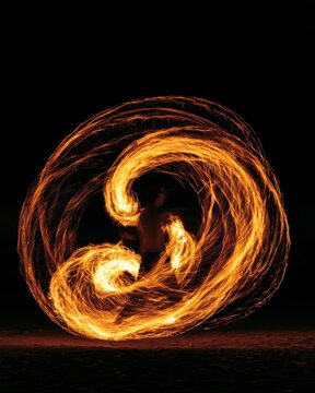 Long exposure of fire spinners performing at a desert festival, circular trails of fire, highly dynamic