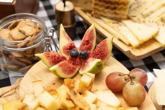 Tabla de quesos curados y suaves acompañados de uvas, higos y pan tostado