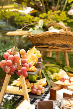 Mesa de aperitivos con quesos variados y frutas frescas de temporada, imagen vertical