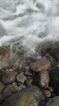 Real-time Video of Top-Down View of Rushing Water and Wet Rocks in Vertical Format