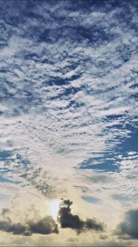 Beautiful Vertical Sky Background with Textured White Clouds and Golden Glow