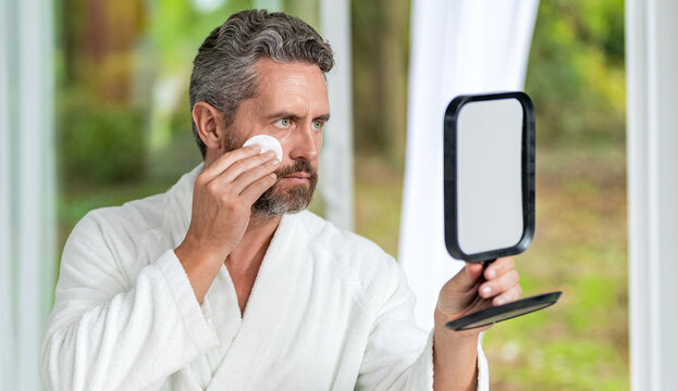 Man cosmetic at mirror. Beauty cosmetic product. Skin care procedures. Man with cosmetic. Skincare beauty. Skincare, face and beauty of man with cotton for cleaning skin. Facial detox cosmetics