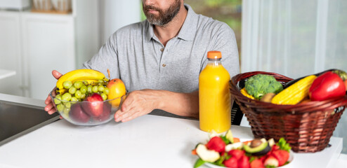 Fototapeta premium Enjoying healthy food. Man eat morning breakfast in kitchen. Hungry man eating lunch. Morning at home. Breakfast in kitchen. Man eating organic vegetable and fruit lunch