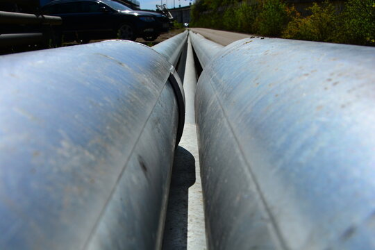 Long steel pipes of large diameter from a low angle in perspective along the road