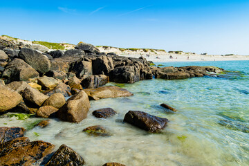 Obraz premium Rocky shoreline and turquoise water at Dogs Bay near Roundstone, Connemara, County Galway. Scenic white sand beach on the Wild Atlantic Way beside Gurteen Bay, Ireland