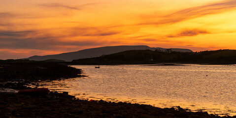 Obraz premium Sunset view of Clew Bay near Westport, County Mayo, Ireland. Scenic orange evening light over the Atlantic inlet and mountains on the Wild Atlantic Way.