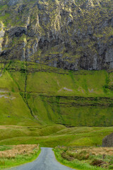 Obraz premium Gleniff Horseshoe in County Sligo, Ireland, with rolling grassland beneath steep limestone mountains and bright clouds. A scenic drive through one of Irelands classic valleys.