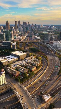 Atlanta, Georgia skyline with prominent skyscraper buildings and expressway stretching across the city. Dense highway traffic and modern transportation infrastructure.