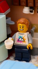 Obraz premium Tambov, Russian Federation - January 17, 2026 A smiling Lego man minifigure standing in a kitchen setting holding a white cup.