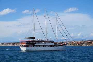 Obraz premium Large classic three-masted wooden sailing ship cruising on the blue Adriatic Sea near the Croatian coast