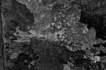Fototapeta premium Weathered peeling black plaster wall texture with cracks and aged paint for grunge backgrounds and designs
