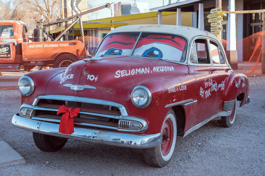 Seligman, Arizona - December 4, 2024: A vintage red Chevrolet with cartoon eyes parked along historic Route 66. This nostalgic roadside attraction inspired the movie Cars by Disney and Pixar.
