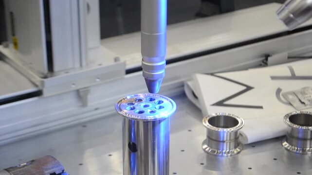 CNC Laser Cutting Machine. Automated laser precisely cutting metal. 5-axis robotic workbench for laser manufacturing. Accuracy automation. Sparks. Manufacturing processes. Precision CNC Technology