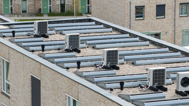 Aerial view of modern heat pump units and skylights on a gravel flat roof of a residential building Almere, Flevoland, Netherlands.