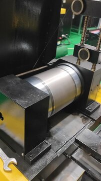 CNC EDM Molybdenum Wire Cutting Machine. Wire EDM machine cutting rotating metal cylinder with thin wire electrode. Industrial. Precision electrical discharge machining. Cutting process Vertical