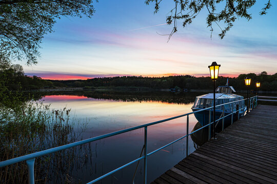 Steg und Boot im Sonnenuntergang am Nebelsee im Fr&uuml;hling in L&auml;rz
