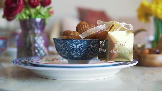 Traditional Eid al-Adha celebration, a festive table setting with dates and a golden gift box, symbolizing generosity and cultural heritage, perfect for religious holiday content.