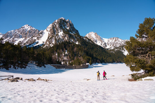 Grupo de chicos haciendo raquetas de nieve en el Parque Nacional de Aig&uuml;estortes y Estany de Sant Maurici, en los Pirineos espa&ntilde;oles. Disfrutan de una ruta de senderismo invernal entre bosques