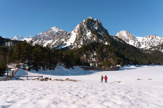 Grupo de chicos haciendo raquetas de nieve en el Parque Nacional de Aig&uuml;estortes y Estany de Sant Maurici, en los Pirineos espa&ntilde;oles. Disfrutan de una ruta de senderismo invernal entre bosques