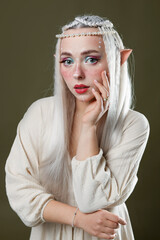 Fototapeta premium Beautiful elf girl on dark olive background