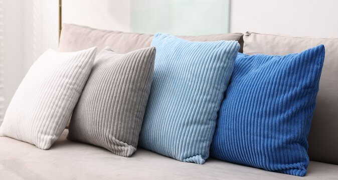 Soft cushions in colorful pillowcases on sofa indoors