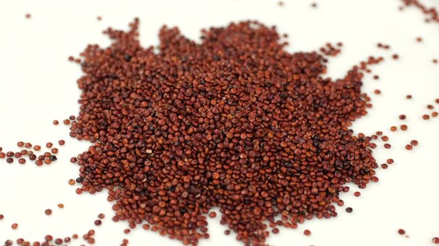 Heap of superfood red quinoa on white background, rotation